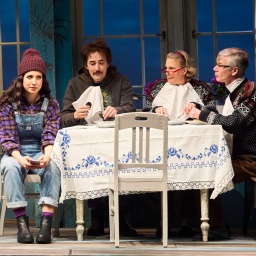 Szenen aus dem Stück Landünner im Ohnsorg Theater. Ein junges Paar und ein älteres Ehepaar sitzen an einem Essenstisch.