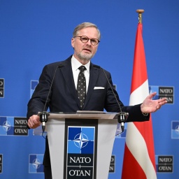 Der tschechische Ministerpräsident Petr Fiala steht an einem Pult und gibt eine Pressestatement. Im Hintergrund ist die tschechische und dänische Fahne zu erkennen. Auf der Wand prangt das NATO-Logo. 