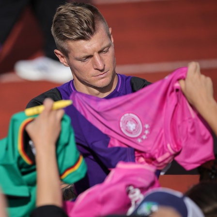 Deutschlands Toni Kroos gibt Fans Autogramme nach dem öffentlichen Training im Adi-Dassler-Stadion.