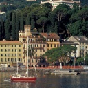 Ein kleines rotes Segelboot vor dem Hafen von Santa Margherita in der italienischen Provinz Ligurien