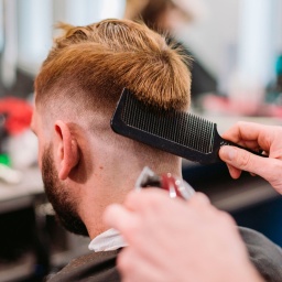 Ein Mann bekommt in einem Barber-Shop einen neuen Haarschnitt