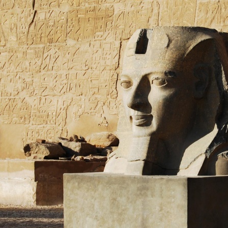 Schon bei ihrer Ankunft in Luxor werden Prof. van Dusen und sein Begleiter vor dem Fluch des Pharao gewarnt. Zu sehen: Eine Pharo-Skulptur vor einer sandfarbenen Wand in Luxor