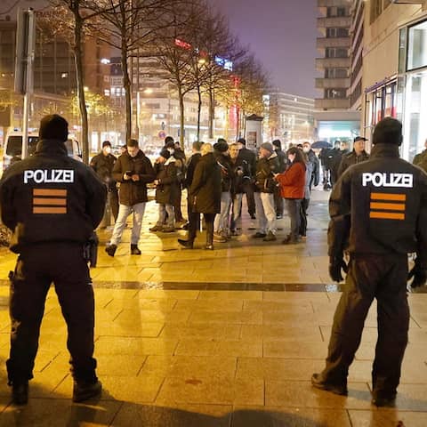 Mehrere Polizeibeamte in voller Schutzmontur stehen Demonstranten in Chemnitz gegenüber.