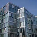 Blick auf eine von viel Glas- und Fensterflächen dominierte Fassade eine Neubaus als Wohnhaus in Berlin Schöneberg.