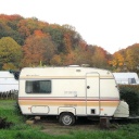 Mehrer Wohnmobile stehen bei Herbstwetter auf einem Campingplatz.