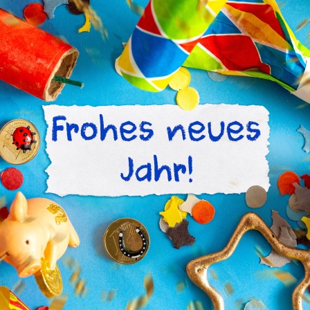 Neujahrssymbole neben dem Text "Frohes neues Jahr!"