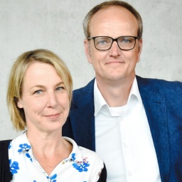 Britta Lange und Olaf Irlenkäuser, das Leitungsteam des Literaturhauses SH, blicken in die Kamera.