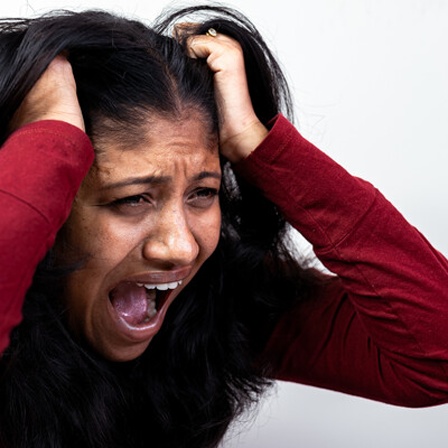 Symbolbild Wut und Verzweiflung: Eine Frau rauft sich die Haare und schreit.