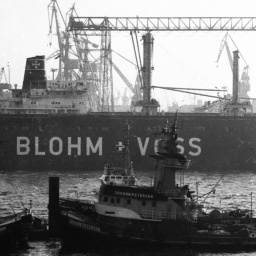 Ein altes Bild vom Hamburger Hafen zeigt die Werft von Blohm + Voss und Schiffe davor.