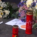 Ein Zettel "Wir gedenken Malte", daneben viele Grablichter und Blumen 