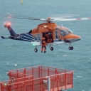Helikopter auf hoher See über Windkraftanlage