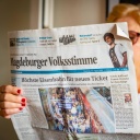 Eine Frau liest die Zeitung Magdeburger Volksstimme.