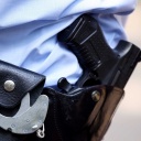 Symbolbild: Ein Polizist mit Handschellen und Schusswaffe am Gürtelbund