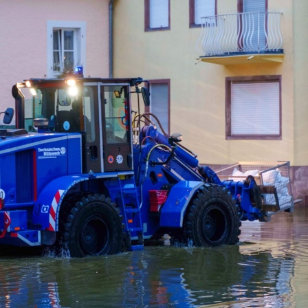  Ein Bagger des THW transportiert in der Innenstadt von Blieskastel Sandsäcke