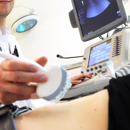 Ein Mediziner führt eine Ultraschall-Untersuchung durch.