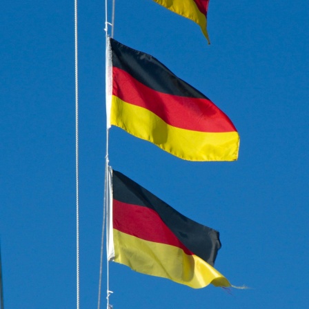 Mehrere Deutschlandfahnen an einem Fahnenmast.