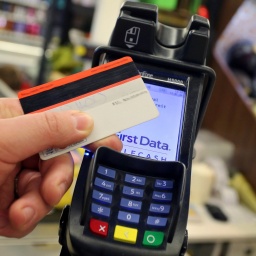 Eine EC-Karte wird an den Bezahl-Terminal an der Kasse eines Supermarktes gehalten.