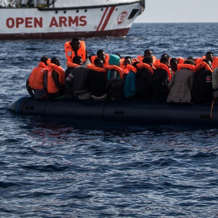 Flüchtlinge die auf einem Schlauchboot im Mittelmeer treiben freuen sich 2018 über die Ankunft eines Schiffes der spanischen Nichtregierungsorganisation Pro Activa Open Arms