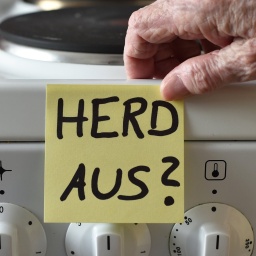 Ein Klebezettel mit dem Schriftzug «Herd aus?» klebt an einem Herd neben den Drehknöpfen. 