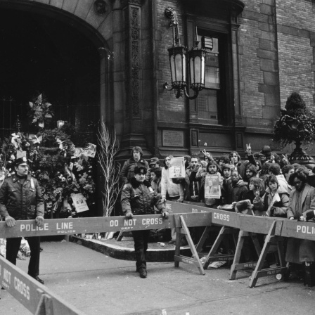 Die Polizei hält Fans am 9. Dezember 1980 vom Dakota-Gebäude in New York City zurück. Hier lebte John Lennon und am Eingang des Hauses wurde der Musiker am Tag zuvor ermordet.