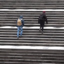 Passanten gehen über eine leicht verschneite Treppe am Raschplatz in der Innenstadt von Hannover.