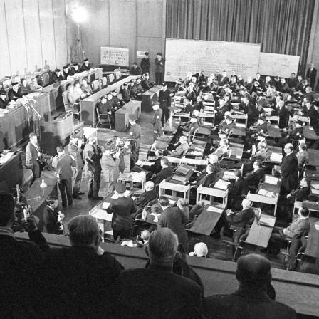 Blick in den Saal des Frankfurter Rathauses, wo 22 ehemalige Wachen und Beamte (rechts abgebildet mit ihren Anwälten und Polizisten) des Konzentrationslagers Auschwitz vor Gericht gestellt wurden. Sie waren für die Tötung von mehr als 2 1/2 Millionen Menschen im Lager verantwortlich. (Aufnahme vom 20. Dezember 1963)