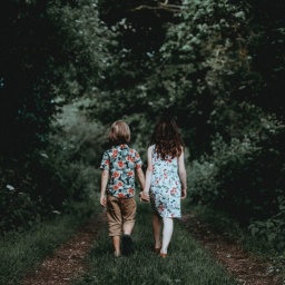 Ein Mädchen und ein Junge - Gretel und Hänsel - laufen in einen dunklen Wald.