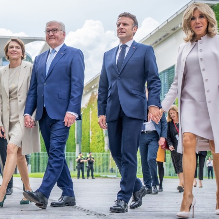 Der Präsident von Frankreich, Emmanuel Macron (2. von rechts), besucht zusammen mit seiner Frau Brigitte Macron (rechts) und Bundespräsident Frank-Walter Steinmeier (2. von links) sowie dessen Frau Elke Büdenbender (links) das Demokratiefest aus Anlass von 75 Jahren Grundgesetz.