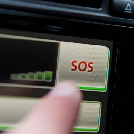 SYMBOLBILD - Ein Schriftzug &#034;SOS&#034; ist auf dem Display eines Bordcomputers mit Touchpad eines Volkswagen Fahrzeuges zu sehen.
