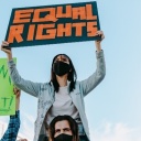 Eine Frau hält ein Schild hoch auf dem "Equal Rights" steht