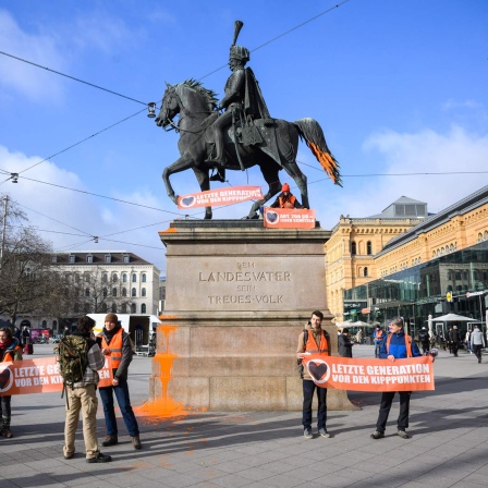 Aktivisten der "Letzten Generation" demonstrieren vor und auf dem Ernst-August-Denkmal vor dem Hauptbahnhof in Hannover. (Quelle: Picture Alliance)