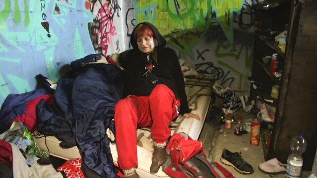 Eine Obdachlose auf einer Matratze.