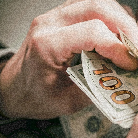 Eine Person zählt die Geldscheine in ihrer Hand.