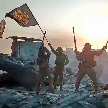 Ein Video-Standbild soll zeigen, wie Soldaten eine russische National- und eine Wagner-Flagge auf einem beschädigten Gebäude in der ukrainischen Stadt Bachmut schwenken.