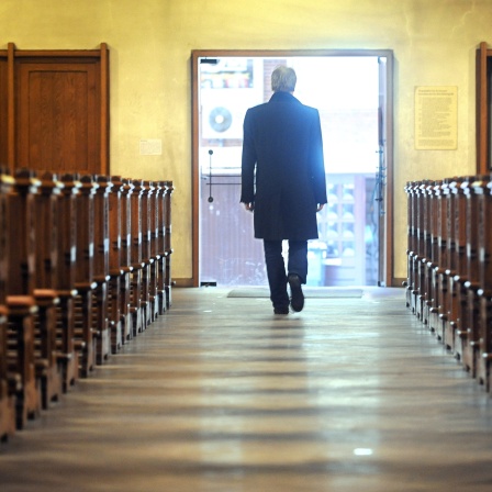 In dieser symbolisch nachgestellten Szene verlässt ein Mann eine Kirche.