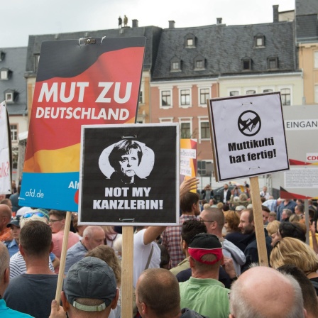 Demonstranten während eines Wahlkampfauftritts von Angela Merkel