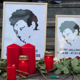 Rosen liegen vor dem Bild von Oury Jalloh am 07.01.2014 am Hauptbahnhof in Dessau-Roßlau (Sachsen-Anhalt). Am 7. Januar 2005 starb der Asylbewerber Oury Jalloh bei einem Feuer in einer Gewahrsamszelle des Polizeireviers in Dessau-RoÃlau.