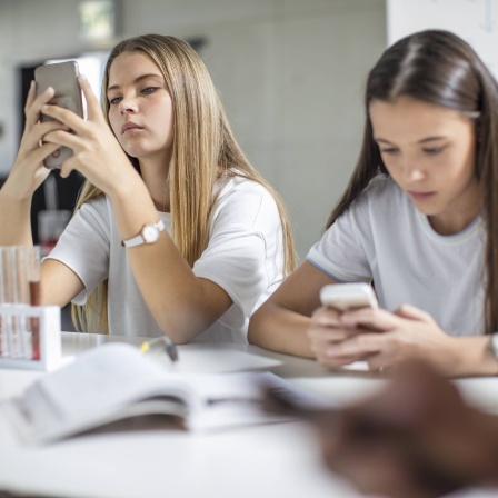 Zwei Schülerinnen mit Smartphone im Chemieunterricht