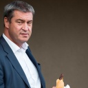 Archivbild: Markus Söder isst ein Bratwurstbrötchen während des Bezirksparteitags der CSU Unterfranken (08.07.2022)