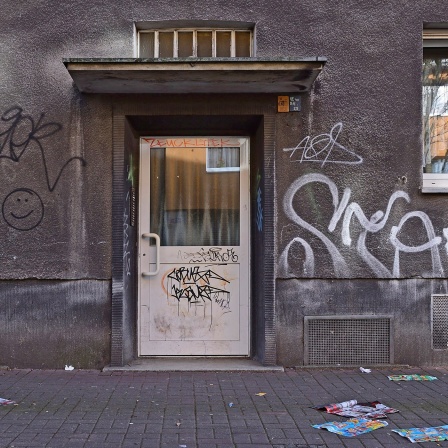 Eingangstür und Fenster eines Wohnhauses in der Nordstadt Dortmund, mit Graffiti besprüht.