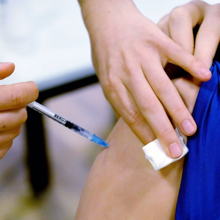 Ein Jugendlicher wird in einem Impfzentrum im Stadtteil Grünau geimpft.