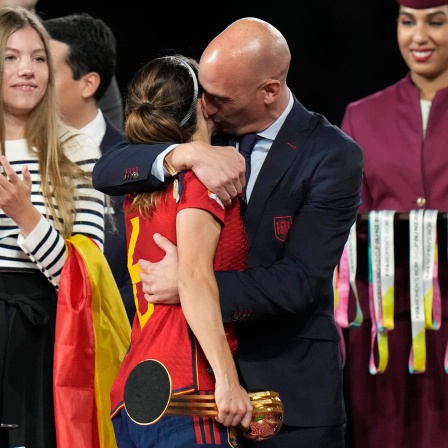 Luis Rubiales (M), Präsident des spanischen Fußballverbandes RFEF, umarmt die spanische Nationalspielerin Aitana Bonmati auf dem Podium nach dem Sieg Spaniens im Finale der Fußballweltmeisterschaft der Frauen gegen England im Stadium Australia in Sydney