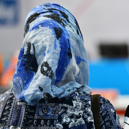 Ein muslimisches Mädchen legt ihre Hand auf die Schulter eines blonden Mädchens.