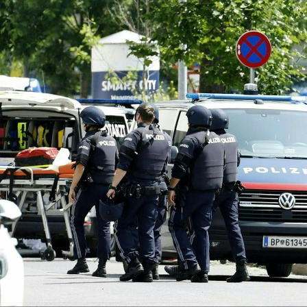 Einsatzkräfte der Polizei und des Notdienstes sind auf einer Straße im Einsatz.