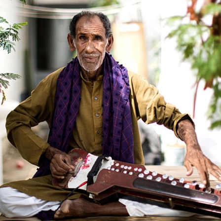 Ustad Noor Bakhsh mit einer Tastenzither, einer sogenannten Benju.