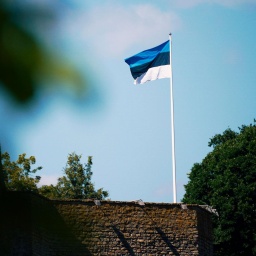 Auf der Burg Narwa in Estland weht eine estnische Flagge: drei gleich breite waagerechte Streifen in Blau, Schwarz und Weiß.