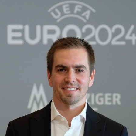 Der ehemalige Fußball-Nationalspieler Philipp Lahm lächelt in die Kamera, im Hintergrund das Logo der EURO 2024