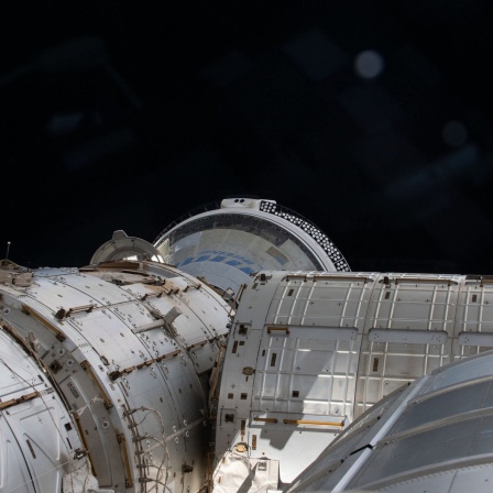 Auf diesem Archivfoto überblickt dieser Blick aus einem Fenster der Kuppel einen Teil des Internationalen Weltraums und zeigt das teilweise verdeckte Starliner-Raumschiff von Boeing, das an der vorderen Öffnung des Harmony-Moduls angedockt ist.