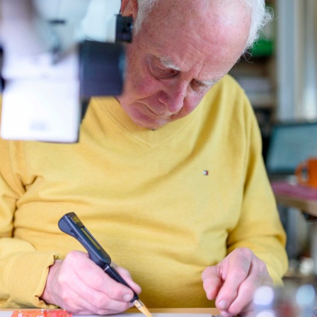 Ein Senior arbeitet in seiner Elektronik-Werkstatt.