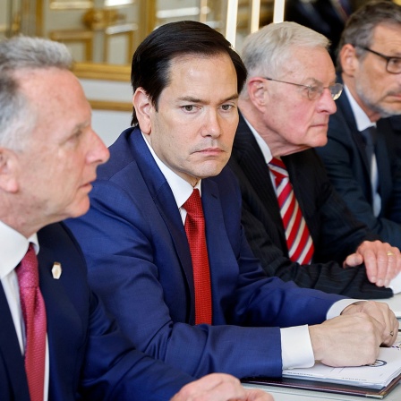 US-Außenminister Marco Rubio (M.) sitzt neben anderen Politikern bei einem Gespräch an einem Tisch.